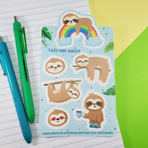 Pode incluir: Uma folha de adesivos de pregui&ccedil;a coloridos com um arco-&iacute;ris e nuvens. Os adesivos dizem "Lazy and Amazay".