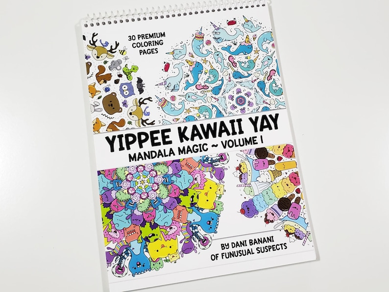 May include: A spiral bound coloring book with a white cover featuring a colorful mandala design and the text "YIPPEE KAWAII YAY MANDALA MAGIC~ VOLUME I BY DANI BANANI OF FUNUSUAL SUSPECTS".