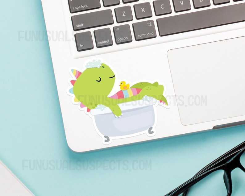 May include: A green dinosaur with a pink and blue striped tail is taking a bath in a white bathtub with a yellow rubber ducky. The dinosaur has a pink and white flower on its head and is surrounded by white bubbles.