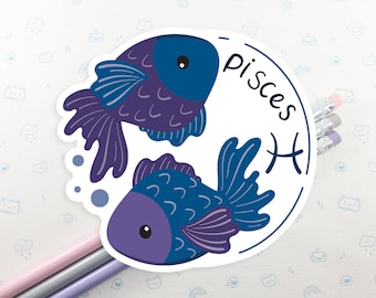 May include: A white sticker with a blue and purple illustration of two fish swimming. The text "Pisces" is written in a curved font on the sticker. The astrological symbol for Pisces is also included.
