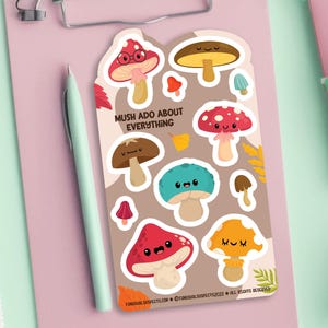 May include: A sheet of colorful mushroom stickers with cute faces. The stickers feature different colors and designs, including red, brown, and yellow. The text "Mush Ado About Everything" is printed on the sheet.
