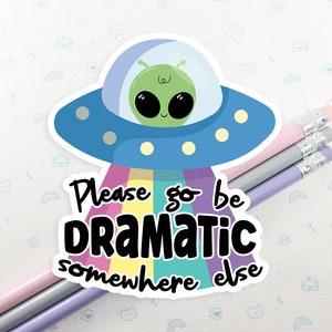 May include: A sticker with a cartoon alien in a spaceship with a rainbow beam of light and the text "Please go be dramatic somewhere else".