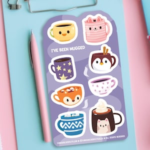May include: A sheet of stickers featuring various mugs with different designs. The mugs are filled with different beverages, including coffee, hot chocolate, and tea. The text "I've Been Mugged" is printed on the sheet.