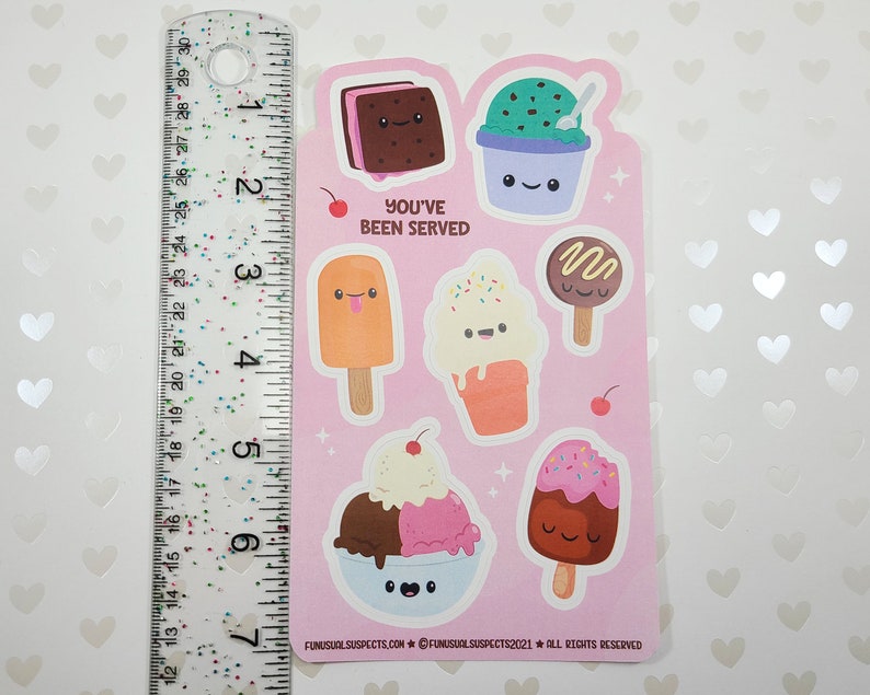 May include: A sheet of stickers featuring various ice cream treats with cute faces. Designs include an ice cream sandwich, a sundae, a popsicle, a cone, and a chocolate-covered ice cream bar. The text "YOU'VE BEEN SERVED" is also included.