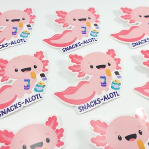 Puede incluir: Un conjunto de nueve pegatinas de ajolote rosa con el texto "SNACKS-ALOTL" en cada pegatina. Los ajolotes sonr&iacute;en y sostienen bocadillos.