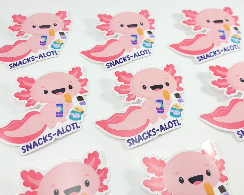 Puede incluir: Un conjunto de nueve pegatinas de ajolote rosa con el texto "SNACKS-ALOTL" en cada pegatina. Los ajolotes sonr&iacute;en y sostienen bocadillos.