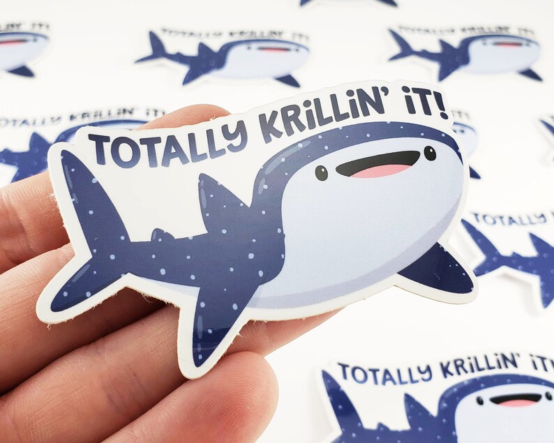 May include: A blue and white whale shark sticker with the text "Totally Krillin' it!" printed on it. The sticker is on a white background.