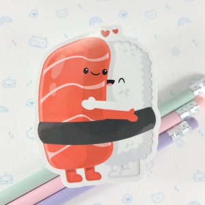 Puede incluir: Una pegatina de dos rollos de sushi abraz&aacute;ndose. El rollo de salm&oacute;n tiene un dise&ntilde;o a rayas rojas y blancas y una envoltura de alga negra. El rollo de arroz blanco tiene un dise&ntilde;o blanco y gris. Ambos rollos tienen caras y brazos lindos.