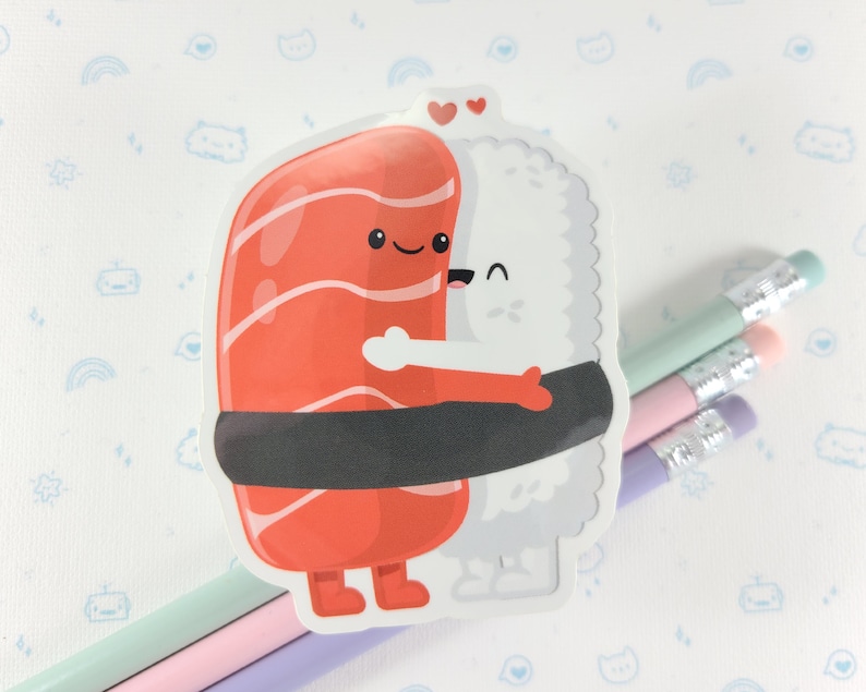Puede incluir: Una pegatina de dos rollos de sushi abraz&aacute;ndose. El rollo de salm&oacute;n tiene un dise&ntilde;o a rayas rojas y blancas y una envoltura de alga negra. El rollo de arroz blanco tiene un dise&ntilde;o blanco y gris. Ambos rollos tienen caras y brazos lindos.