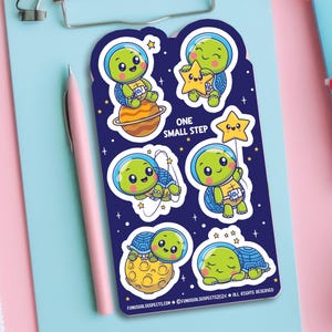 May include: A set of six colorful stickers featuring cute cartoon turtles in space. The stickers are on a blue background with stars and planets. The text "One Small Step" is printed on the stickers.