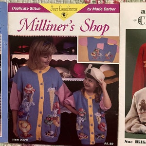 May include: Three knitting pattern books with colorful sweaters featuring duplicate stitch designs. The first book is titled "Stoney Creek Collection Duplicate Stitch" and features a white sweater with a bunny and carrot design. The second book is titled "Just Cast Stitch Milliner's Shop" and features a blue sweater with a hat and flower design. The third book is titled "An Old Fashioned Christmas" and features a red sweater with a gingerbread man design.