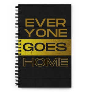 Puede incluir: Cuaderno espiral negro con un patrón de ladrillo dorado y el texto "EVERYONE GOES HOME" en letras doradas.