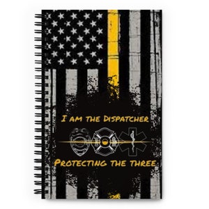 Puede incluir: Una libreta negra y amarilla con un diseño de bandera estadounidense y el texto "I am the Dispatcher Protecting the Three". La bandera tiene una franja amarilla en el medio y el texto es blanco.