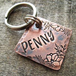 Puede incluir: Chapa de perro de cobre con acabado martillado y dise&ntilde;o floral. La chapa est&aacute; grabada con el nombre "PENNY".