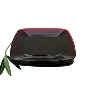May include: A stack of four square glass plates with a dark red rim. The plates are stacked on a white background.