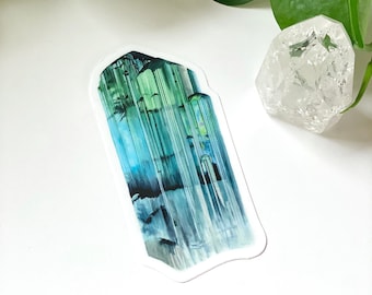 May include: A sticker featuring a detailed illustration of a green and blue crystal with a textured surface.