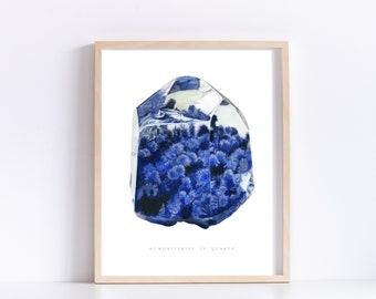 May include: A framed print of a watercolour painting of a clear quartz crystal with blue dumortierite inclusions. The text "Dumortierite in Quartz" is printed below the crystal.