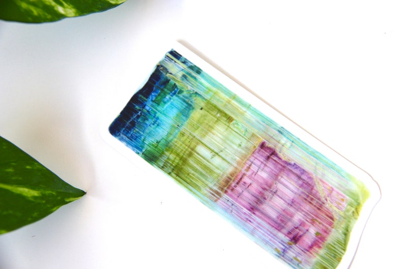 May include: A rectangular ceramic dish with a colorful abstract design. The design features vertical stripes of blue, green, yellow, and pink.