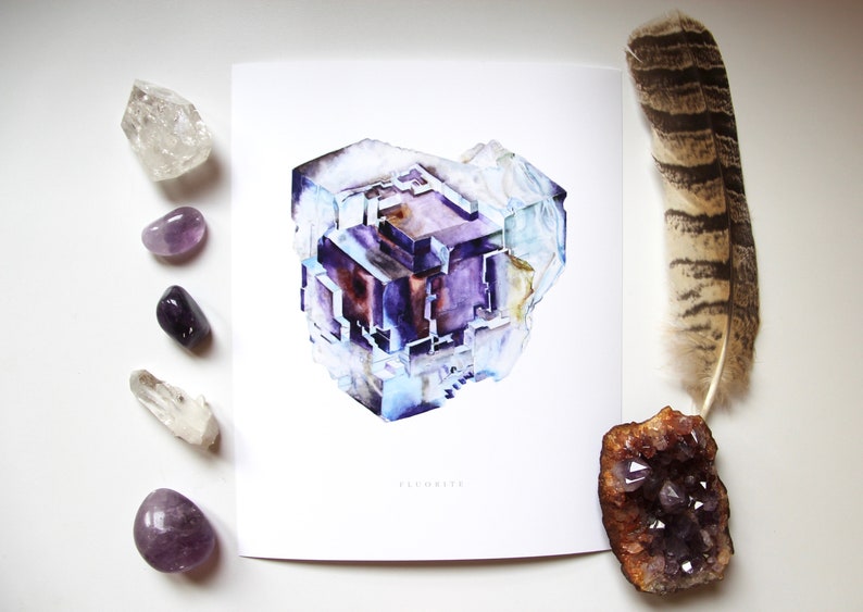 May include: A watercolor painting of a fluorite crystal. The crystal is a deep purple color with white and blue accents. The painting is on a white background with the word "Fluorite" printed below the crystal.