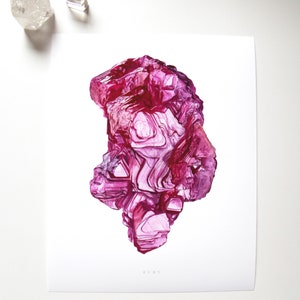 Può includere: Un dipinto ad acquerello di un cristallo di rubino. Il cristallo è di colore rosso intenso e ha una superficie ruvida e testurizzata. Il dipinto è su uno sfondo bianco e la parola "RUBY" è scritta in piccole lettere in basso.