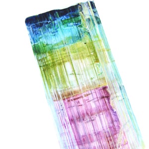 May include: A close-up of a multi-colored crystal with shades of blue, green, purple, and yellow. The crystal has a striated texture and is translucent.