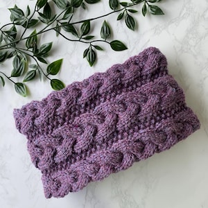 May include: Purple knitted headband with a cable knit pattern.