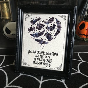 Könnte beinhalten: Schwarz gerahmter Kunstdruck mit einem Aquarell-Fledermaus-Herz. Der Text lautet: "Du bist mir lieber als alle Fledermäuse in allen Höhlen auf der ganzen Welt."