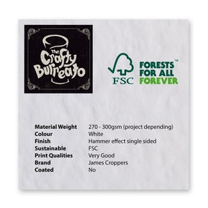 May include: A white card with black text describing the material weight, colour, finish, sustainability, print qualities, brand, and coated properties of a product. The card also features a black and white logo for "The Crafty Buffalo" and a green logo for "Forests for All, FSC Forever."
