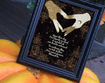 Peut inclure: Une impression encadrée en noir avec un motif doré de deux mains formant un cœur. L'impression contient un poème sur l'amour et l'engagement avec le texte "Upon this day Our hands we bind A symbol of our hearts entwined To witness this we ask of thee Our union forever Blessed be."