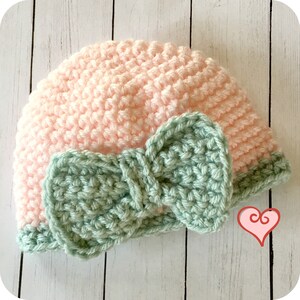 May include: A pink crocheted hat with a green crocheted bow. The hat is made with a single crochet stitch and the bow is made with a double crochet stitch.
