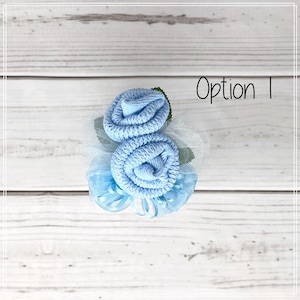 May include: A light blue sock flower bouquet with tulle and ribbon accents. The bouquet is labelled "Option 1".
