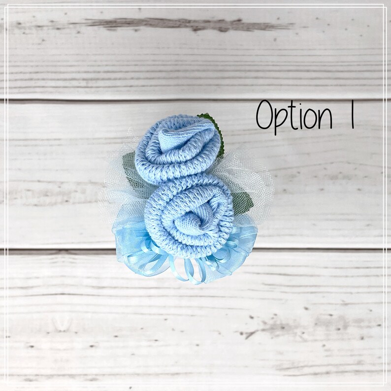 May include: A light blue sock flower bouquet with tulle and ribbon accents. The bouquet is labelled "Option 1".