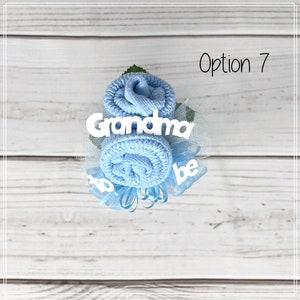 May include: A blue sock flower bouquet with white text that reads "Grandma to be".