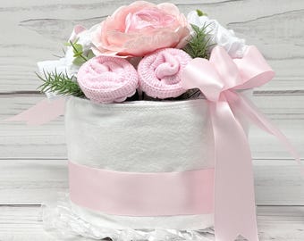 Pastel de pañales con lazo rosa: Centro de mesa para baby shower coqueto