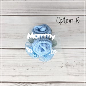 May include: A blue sock flower bouquet with white tulle and the text "Mommy to be".