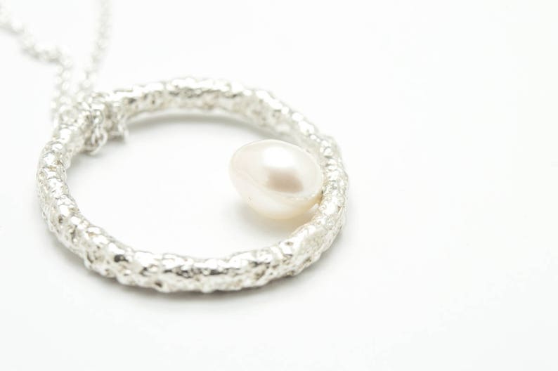 Zarte Perlenkette. Kleine Perle aus natürlichem Süßwasser auf einem strukturierten Kreis aus Sterlingsilber. Runder Anhänger mit Perle. Bild 5