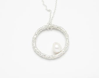 Pearl necklace. Small natural freshwater pearl on a sterling silver textured circle