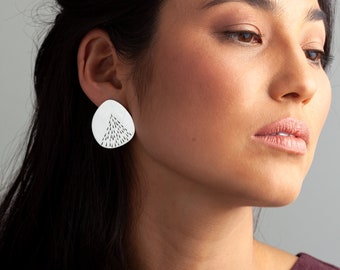 LENA. Large earrings engraved with small drops on a reflective silver surface