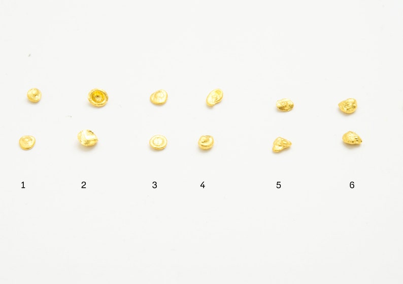 May include: Six rows of gold nuggets of varying sizes and shapes. The nuggets are arranged in rows, with the largest nuggets at the top and the smallest nuggets at the bottom.
