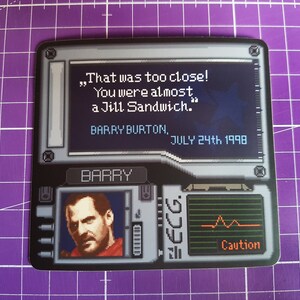 K&ouml;nnte beinhalten: Ein schwarzer und grauer Aufkleber im Videospiel-Stil mit einem pixeligen Bild eines M&auml;nnergesichts und einer Nachricht, die lautet "That was too close! You were almost a Jill Sandwich." Der Text unter der Nachricht lautet "BARRY BURTON, JULY 24th, 1998". Der Aufkleber enth&auml;lt auch ein pixeliges Bild eines Herzfrequenzmonitors mit dem Wort "Caution" angezeigt.