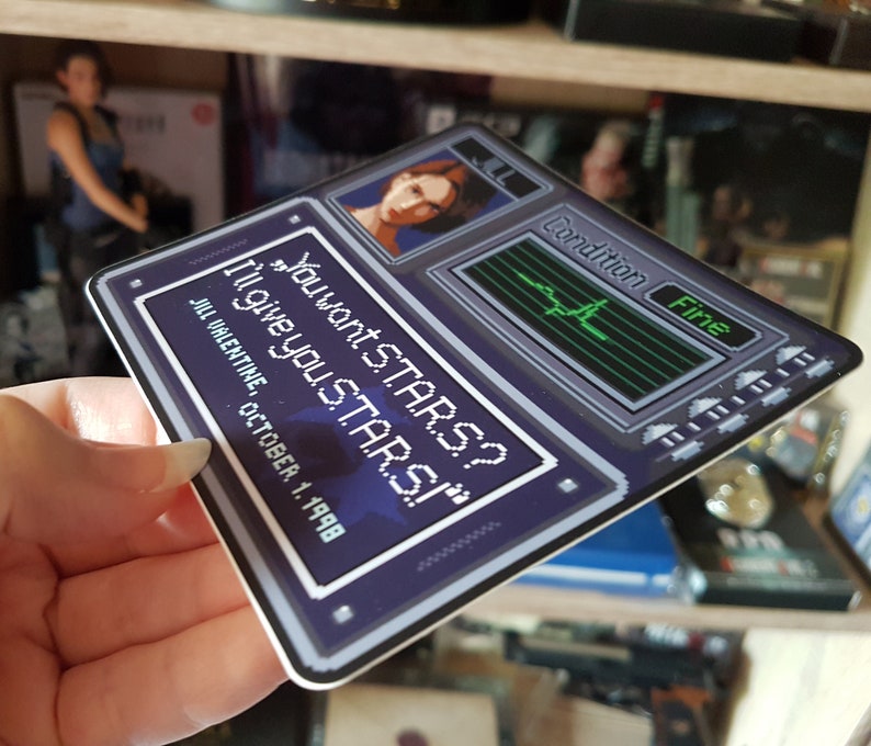 May include: A blue and gray sticker with pixelated text that reads "You want STARS? I'll give you STARS!" with a pixelated image of a woman's face in the top left corner. The sticker also has a pixelated image of a heart rate monitor with the text "Condition Fine" in the top right corner.