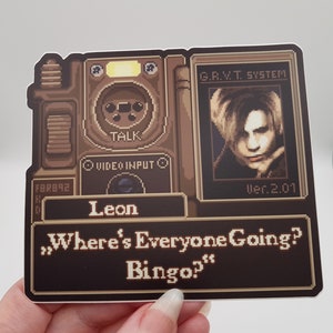 Peut inclure: Une image pix&eacute;lis&eacute;e d'un personnage de jeu vid&eacute;o, Leon, du jeu Resident Evil 2. L'image est dans le style d'une console de jeu vid&eacute;o r&eacute;tro. Le texte "Where's Everyone Going? Bingo?" est affich&eacute; &agrave; l'&eacute;cran.