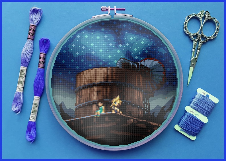 Peut inclure: Un cerceau de broderie au point de croix termin&eacute; avec une image pix&eacute;lis&eacute;e d'une sc&egrave;ne de jeu vid&eacute;o. La sc&egrave;ne repr&eacute;sente deux personnages debout sur une plateforme en bois contre un ciel nocturne bleu avec des &eacute;toiles. Le cerceau est sur une surface bleue avec du fil &agrave; broder bleu et des ciseaux.