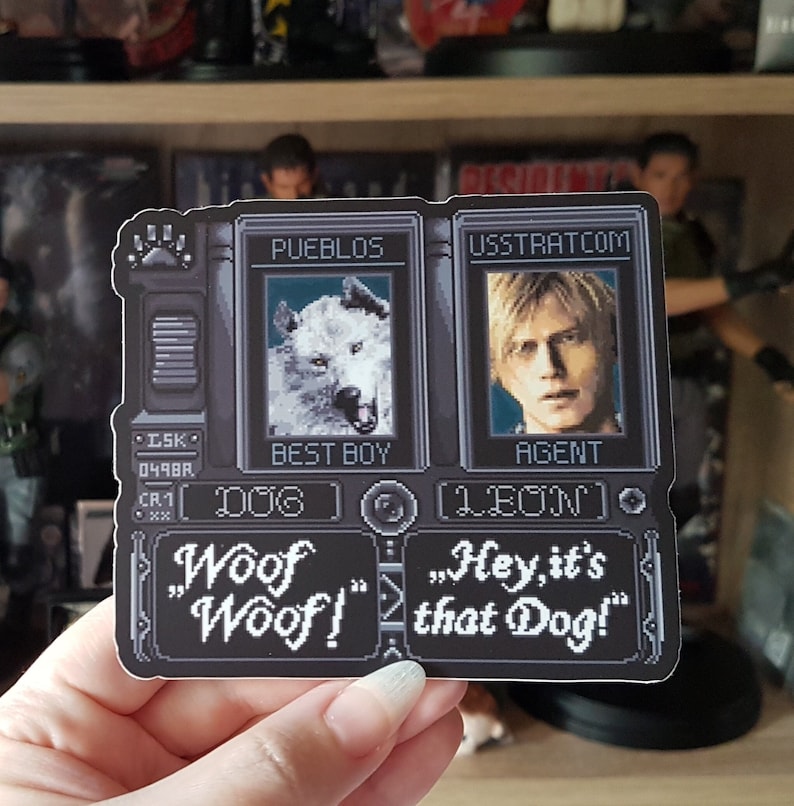 May include: A black and white sticker with a pixelated design. The sticker features two characters from the video game Resident Evil 4. The first character is a white wolf with the text "Best Boy" and "Dog" below. The second character is a man with the text "Agent" and "Leon" below. The sticker also includes the text "Woof "Woof!" and "Hey, it's that Dog!"