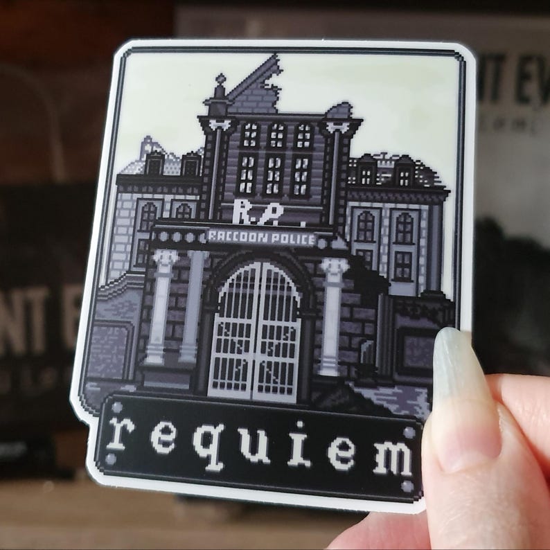 May include: A grayscale sticker featuring a pixelated illustration of a building with the text "Raccoon Police" above a large gate. Below the building is the word "requiem" in white letters on a black background.