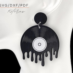 May include: Black and white vinyl record earring with dripping edges. The earring is made of wood and has a silver hook.