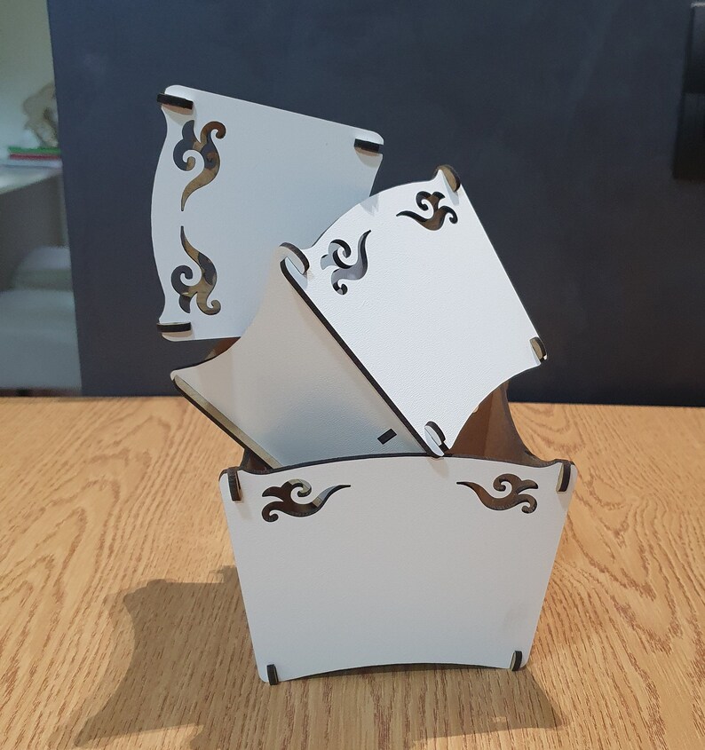 May include: White wooden planter with a decorative design. The planter is made of three pieces that fit together. The planter is empty and ready to be filled with plants.