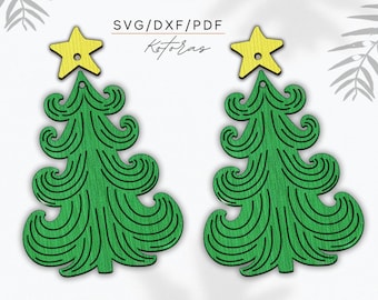 May include: A pair of green Christmas tree earrings with yellow star toppers. The trees are made of swirling lines.