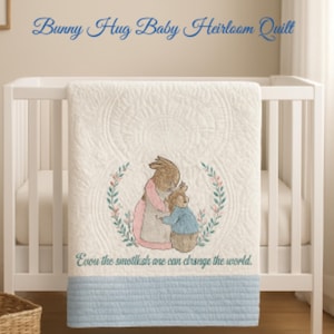 Puede incluir: Una colcha blanca para bebé con un diseño de conejito, exhibida en una cuna blanca. La colcha presenta una imagen bordada de dos conejitos abrazándose, rodeados por una corona floral. El texto "Bunny Hug Baby Heirloom Quilt" está arriba.