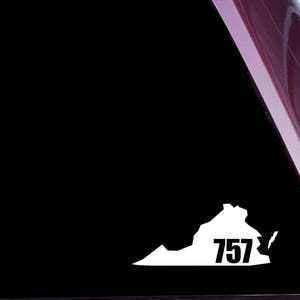 Op de afbeelding: Witte vinyl sticker van de staat Virginia met het nummer 757 binnen de omtrek. De sticker zit op een donkerrood autovenster.